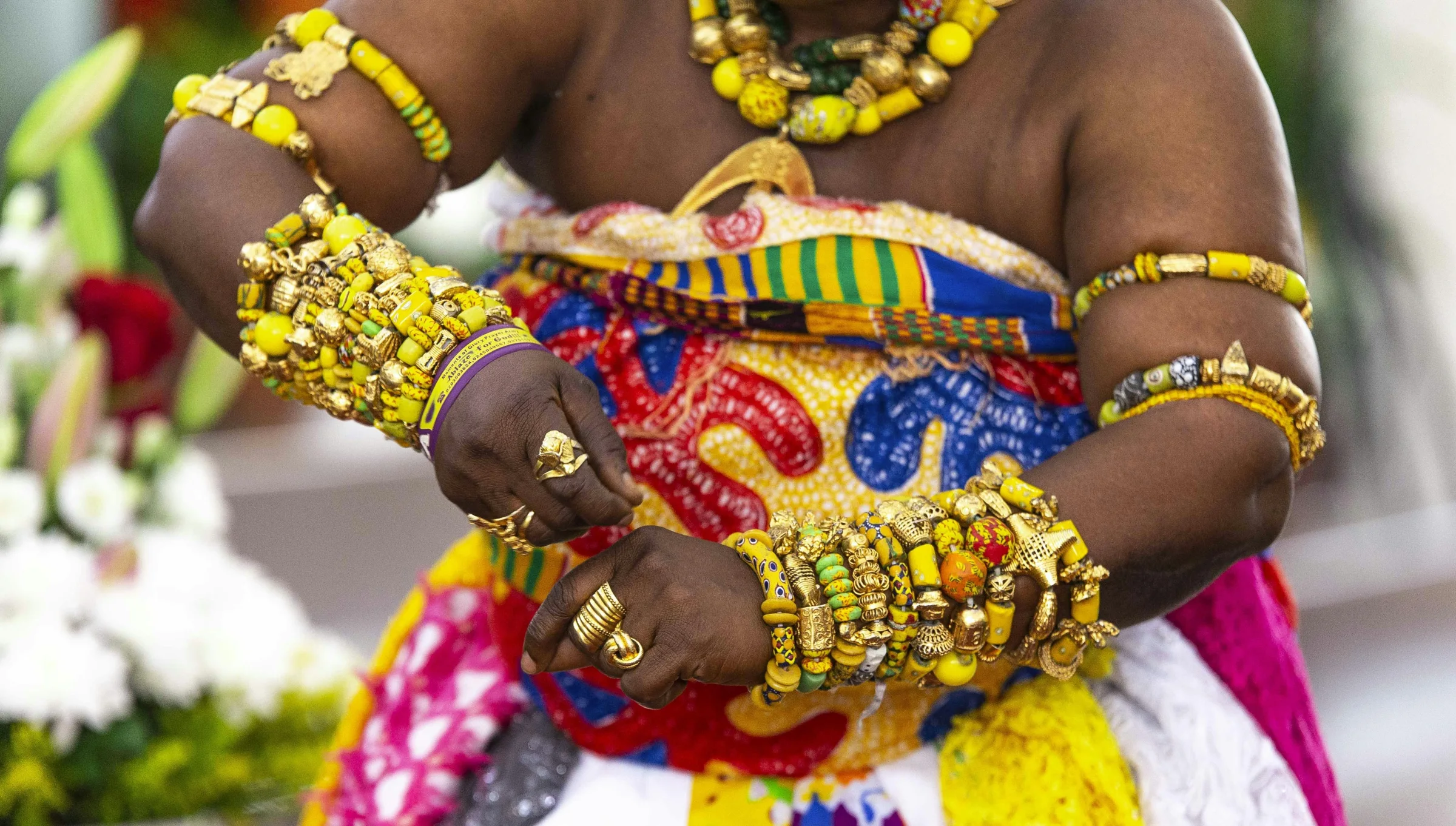 Ghanaian artisan presenting colorful handmade jewelry