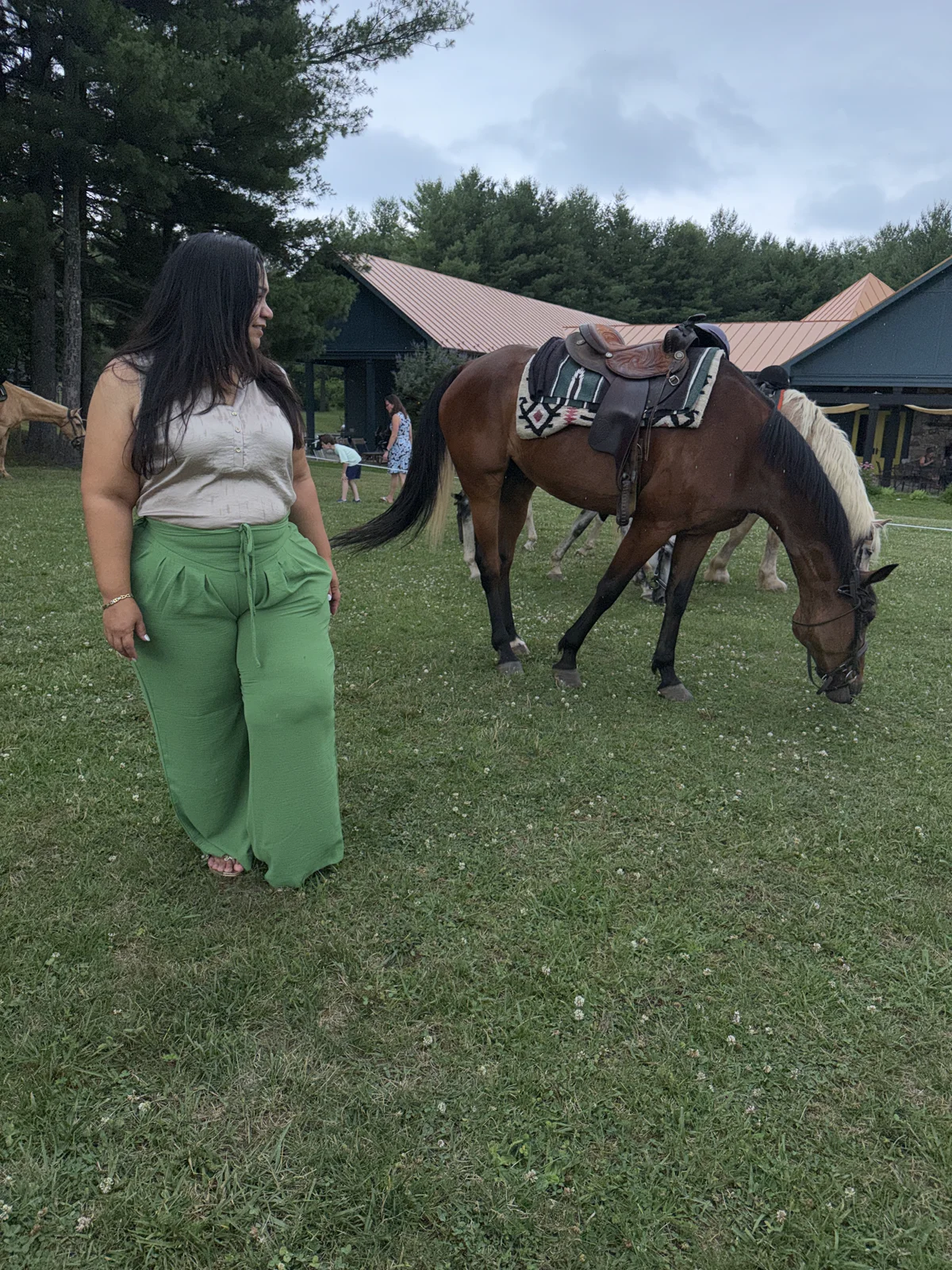 LDTG traveler in green sharing a quiet moment beside a horse